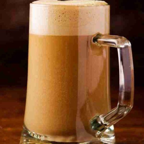 a mug of butterbeer sits foaming, ready for a Harry Potter party.